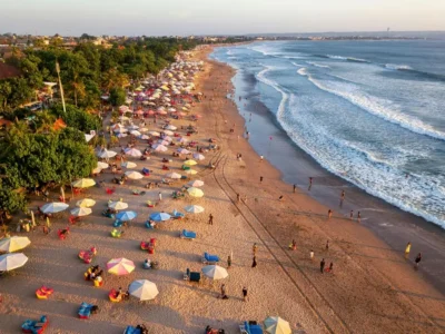 Aerial view of Kuta Beach with umbrellas and waves in Bali