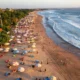 Aerial view of Kuta Beach with umbrellas and waves in Bali