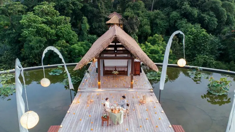 Couple dining on a private deck surrounded by greenery