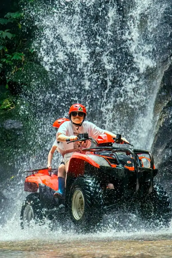 Two participants riding past the waterfall on the 90-minute Premium Track